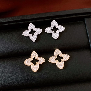 Macro shot of silver and rose gold flower earrings with pavé zircons in luxury box