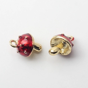 Macro detail of red and gold alloy mushroom pendants with polka dot drip oil finish