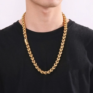Close-up of a chunky gold punk skull necklace worn by a model on a black t-shirt