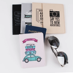 Colorful PU leather passport covers with travel prints and sunglasses on a white surface