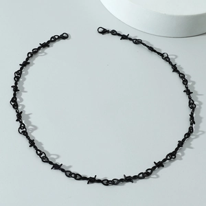 Macro shot of black thorn choker necklace featuring dual lobster clasps and punk metal texture