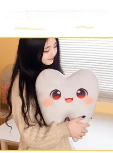 Gros plan du joli coussin dent en peluche avec yeux de dessin animé et joues roses à la maison