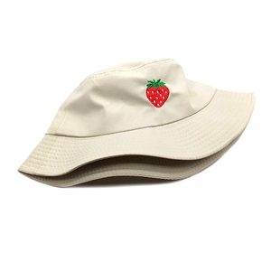 Close-up of strawberry embroidery on beige cotton bucket hat with clean stitching details