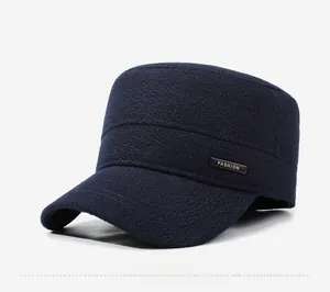 Detail of navy blue flat top military cap featuring a gold fashion metal plate