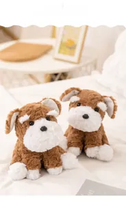 Close-up of brown and white Schnauzer plush dolls in a cozy home bedroom setting