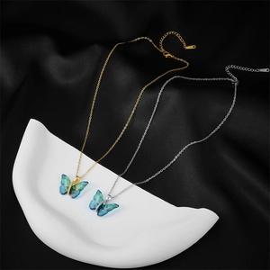 Elegant gold and silver titanium butterfly necklaces with blue gradient pendants on silk