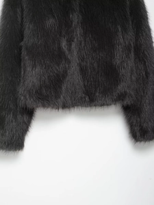 Macro detail of high-quality black faux fur texture and stitching on short jacket