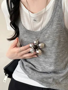 Macro shot of large silver flower necklace with amber-like stone on snake chain