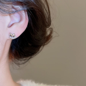 Détail de boucles d'oreilles cheval à bascule argentées avec cristaux sur un mannequin