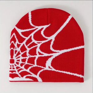 Detailed close-up showing the red and white spider web jacquard knit pattern on the beanie
