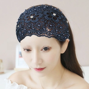 Detail of navy blue lace headband with pearl accents and floral hollow pattern