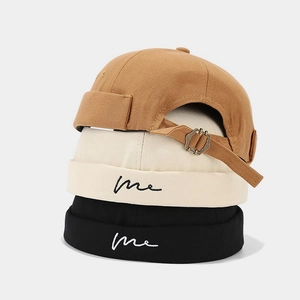 Docker hats in caramel, beige, and black featuring wave embroidery and metal buckles