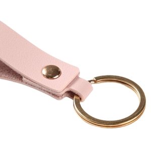 Pink textured leather keychain strap with golden metal rivet and split ring on white background