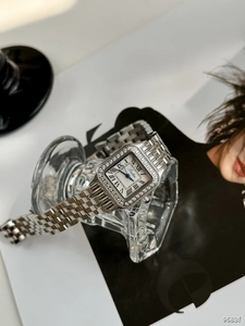 Close-up of square silver watch with Roman numerals and diamond-encrusted bezel