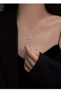 Close-up of elegant 925 silver necklace featuring a dancing H-letter pendant with zircon stone