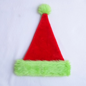 Detail view of red Christmas hat featuring soft green plush trim and fuzzy pom-pom