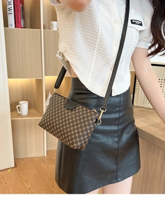Detail of vintage geometric print crossbody bag with black leather strap and gold buckle