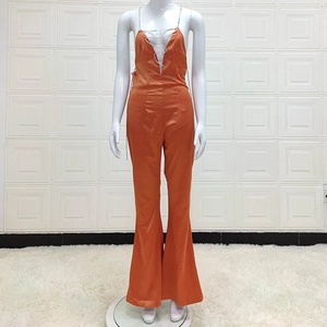 Combinaison en satin orange vif avec décolleté plongeant et chaînes métalliques