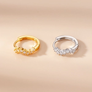 Detailed view of floral and geometric zircon earrings in gold and silver finishes