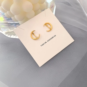 Gros plan sur des boucles d'oreilles croissant de lune dorées serties de zircones