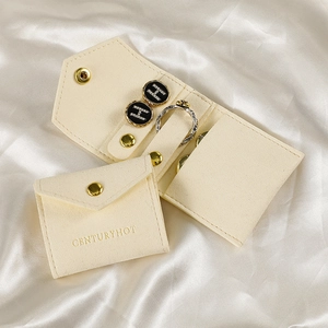 Microfiber jewelry rolls in cream suede showing open flower ring and stud earrings