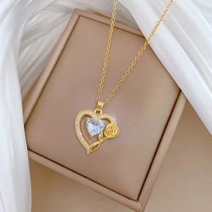 Close-up of gold heart pendant necklace featuring central zircon and rose detail