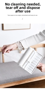 Detail van een hand die het diagonaal klevende papier van een pluisroller afpelt