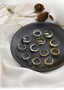 Macro shot of minimalist silver and gold stacked ring set on a black ceramic plate