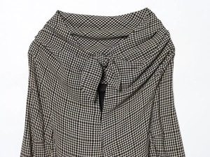 Detail of classic houndstooth pattern fabric with elegant bow tie-neck on women's top