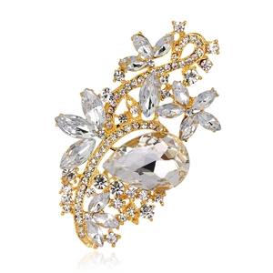 Detailed macro view of a golden crystal floral brooch with pear-shaped center stone