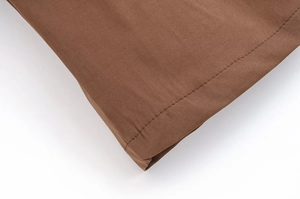 Détail macro du tissu tissé marron foncé avec couture droite et ourlet de haute qualité
