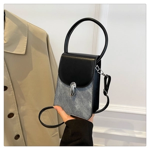 Detail of grey denim and black PU mini crossbody bag with silver buckle and handle