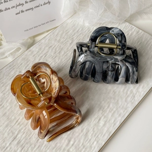 Detail of large marble and amber ink-wash hair claws with durable metal springs