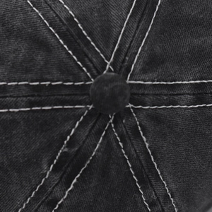 Detailed macro view of black washed denim baseball cap with contrast white stitching