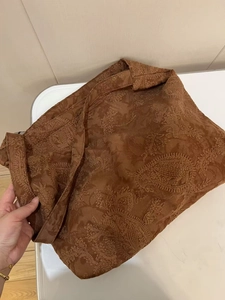 Close-up of vintage paisley embroidery on brown suede tote bag with textured floral patterns