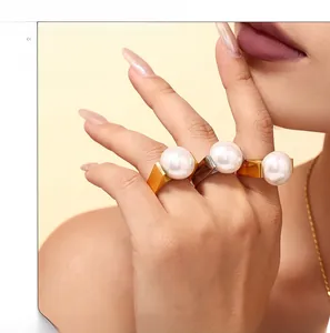 Close-up of geometric 18K gold plated titanium rings with large white round pearls