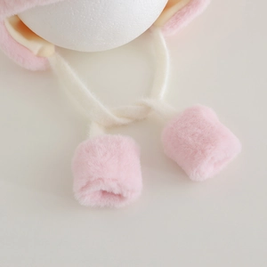 Detail of pink plush earflap hat showing soft texture and thick pom-pom ties for babies