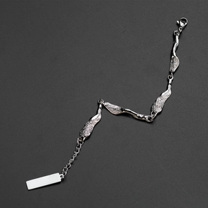 Minimalist silver irregular link bracelet with rectangle tag on dark textured surface