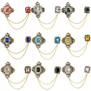 Macro detail of nine colorful gemstone brooches with double gold chains and vintage alloy frames