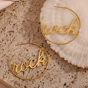 Detail of 18K gold-plated hoop earrings with creative rock lettering on stone