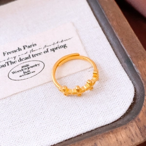 Detailed close-up of vintage gold-plated ring with relief texture on white fabric
