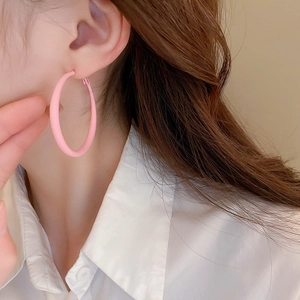 Close-up of model wearing matte pink acrylic round hoop earrings for a stylish look