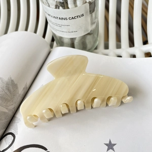 Elegant cream marble acetate hair claw clip on magazine with minimalist aesthetic