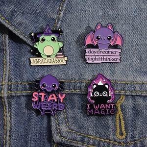 Set of four cartoon magic animal enamel pins featuring a frog, bat, cat, and spider on denim