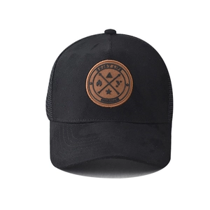 Close-up of brown leather patch with Enjoy Life engraving on black mesh baseball cap