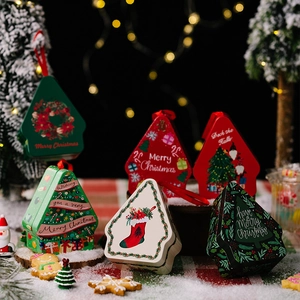 Detail of house-shaped Christmas tin boxes with festive prints for holiday gift packaging