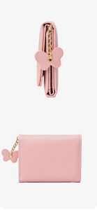 Detail view of pink women's wallet with golden chain and butterfly charm decoration