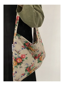 Detail view of floral cotton tote bag with vintage flower print worn by model