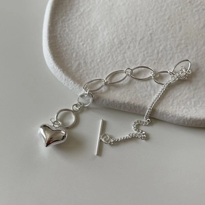 Detail of silver S925 heart pendant bracelet featuring OT clasp and dual layered chains