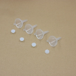 Detailed overhead view of four transparent plastic funnels with white round lids on kraft paper